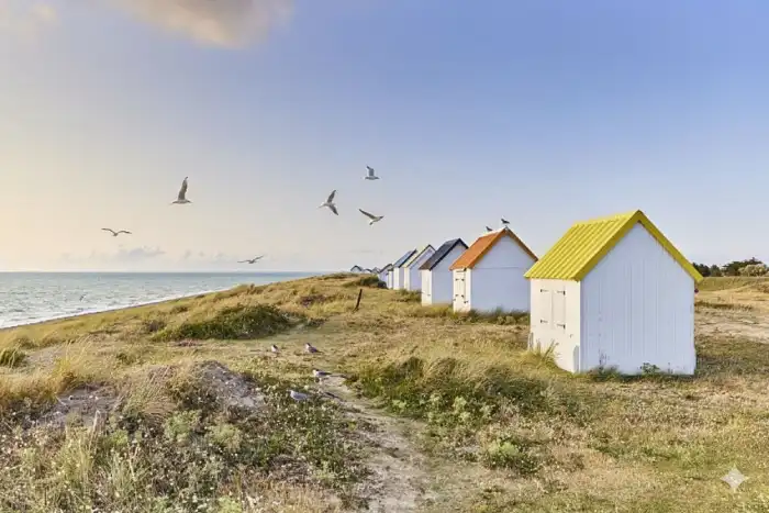 Vue sur des cabanes de plage lors d’une randonnée dans la Manche en bord de mer