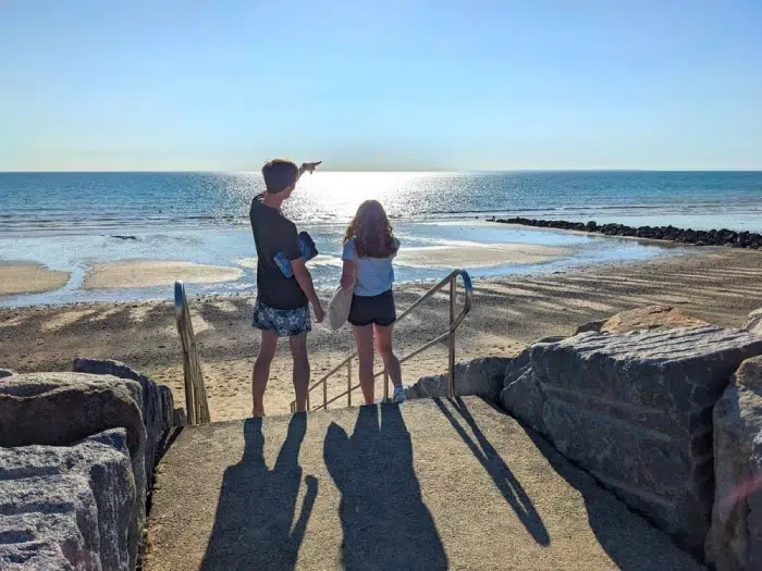 Deux enfants admirant la mer depuis les rochers à Agon-Coutainville – camping Granville bord de mer